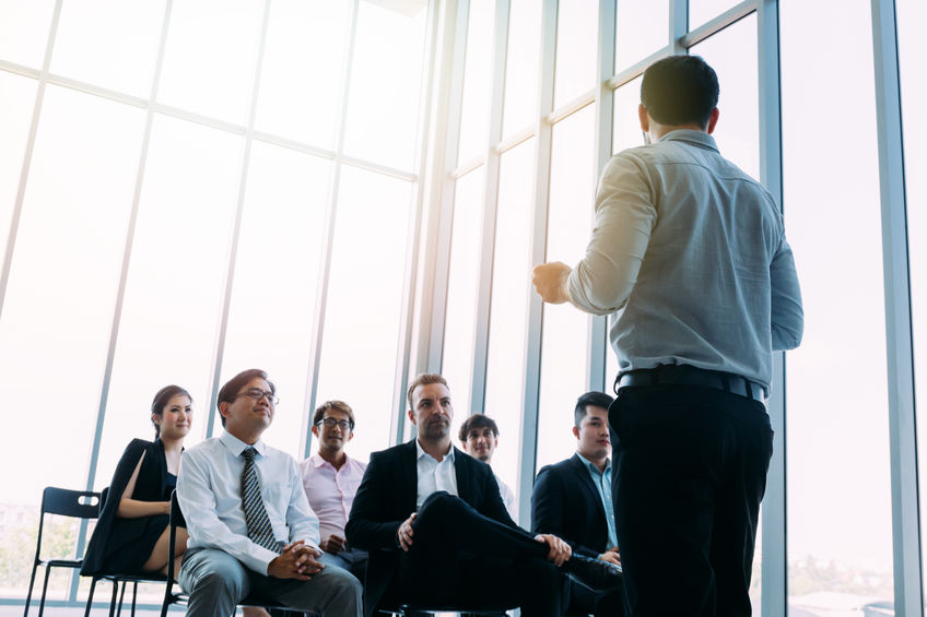 Man talking to coworkers in conference hall Man talking to coworkers in conference hall